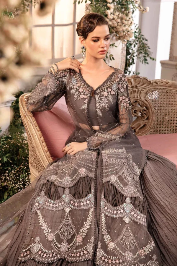 Designer grey saree with silver threadwork and net dupatta, styled in a floral-themed backdrop.