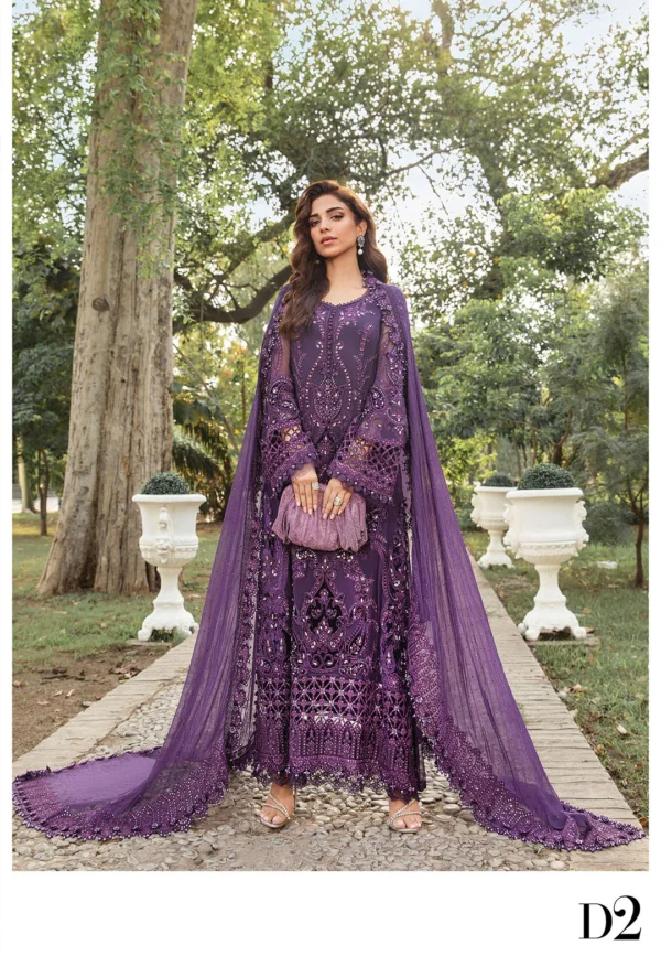 A model in a deep purple embroidered formal outfit with intricate embellishments and a flowing dupatta, posing elegantly in an outdoor garden.