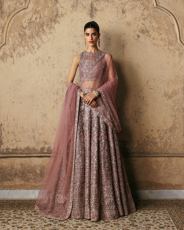 Woman wearing elegant pastel pink lehenga choli with embroidery